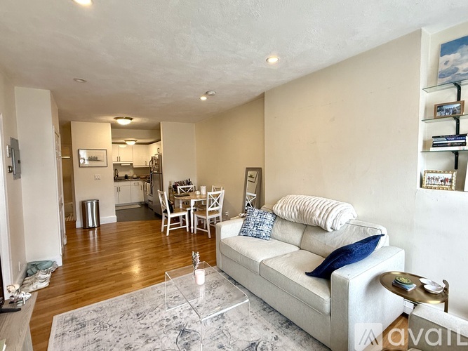 A bedroom with a bed, nightstand, and three pictures on the wall.