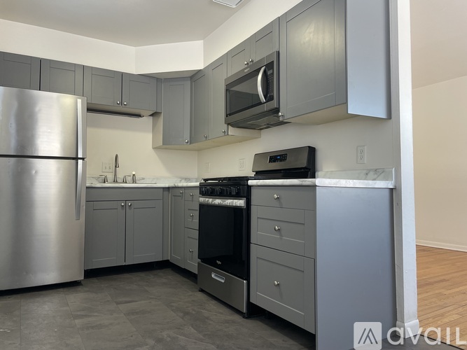 A kitchen with a stainless steel refrigerator and a black stove top oven.