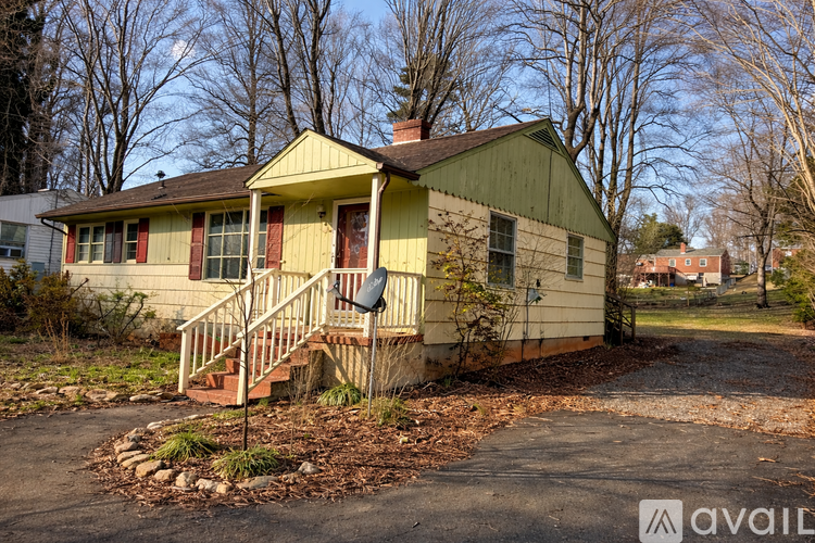 A yellow house with a red door and a small front porch.