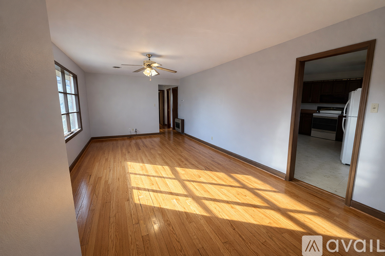A room with wooden floors and a ceiling fan.