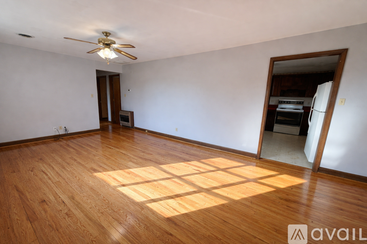 A room with wooden floors and a ceiling fan.