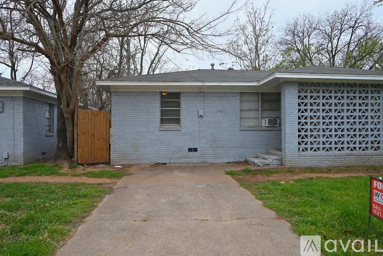 A house with a brown door and a sign that says "For Sale".
