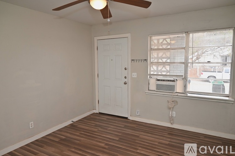 A room with a white door and a window with blinds.