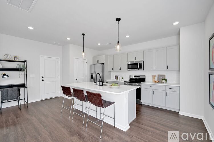 A kitchen with white cabinets and a wooden floor.