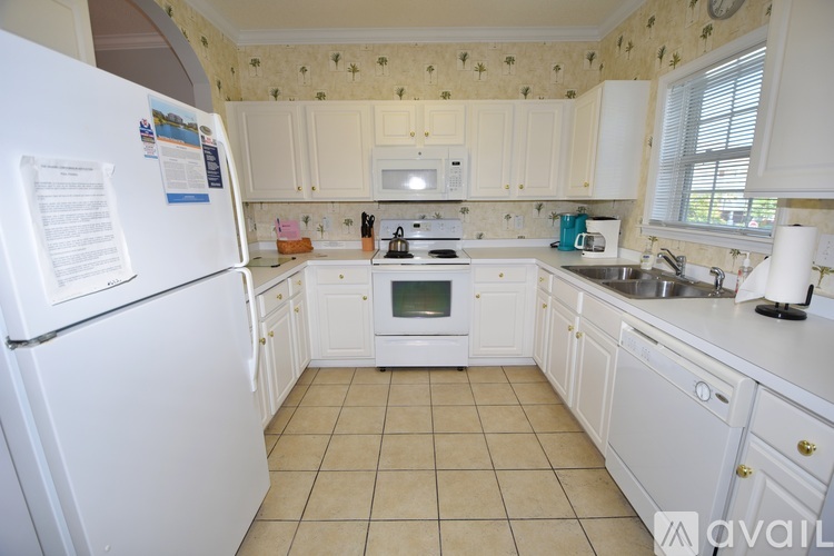 A kitchen with white appliances and cabinets.