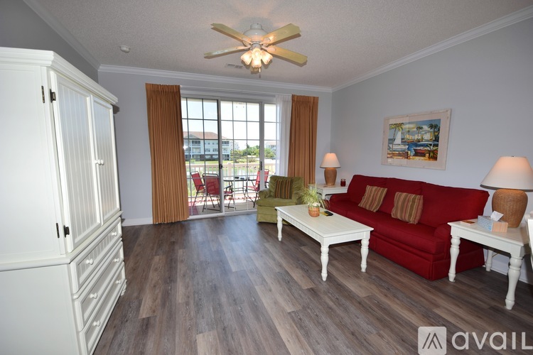 A living room with a red couch, white coffee table, and a ceiling fan.