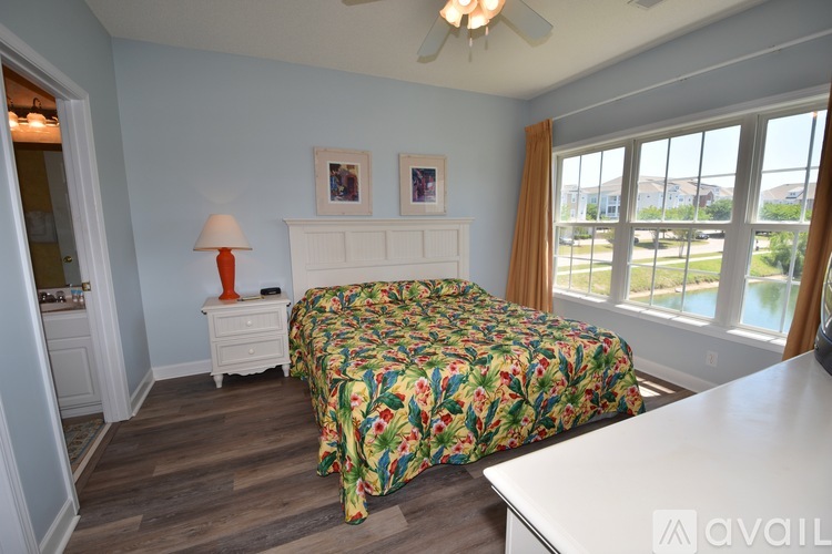 A bedroom with a bed, dresser, and window.
