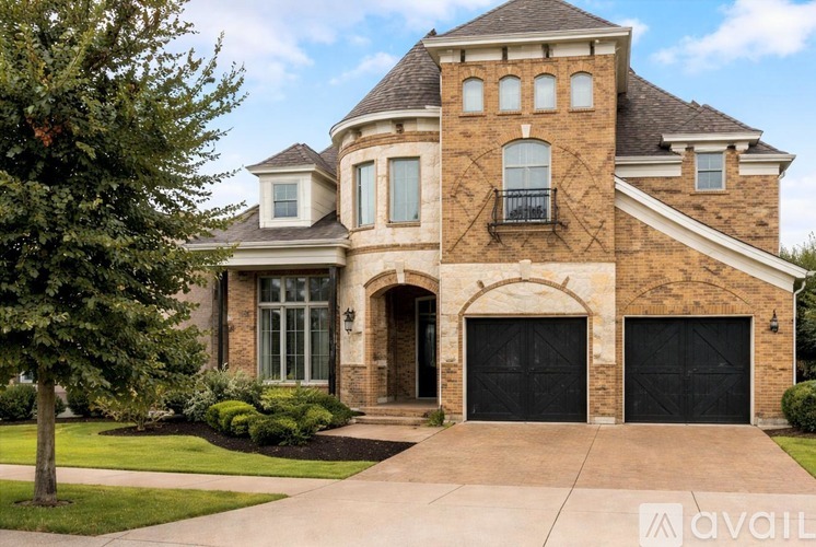 A large, two-story house with a stone exterior and a large front yard.