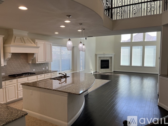 A spacious kitchen with a curved island in the middle.