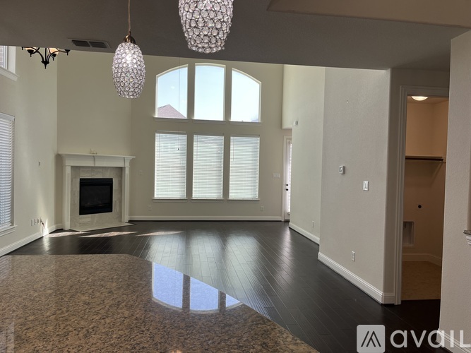 A spacious living room with a fireplace and a large window.