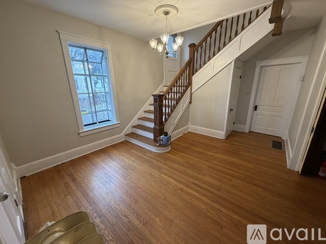 A spacious room with a staircase leading to the upper floor.