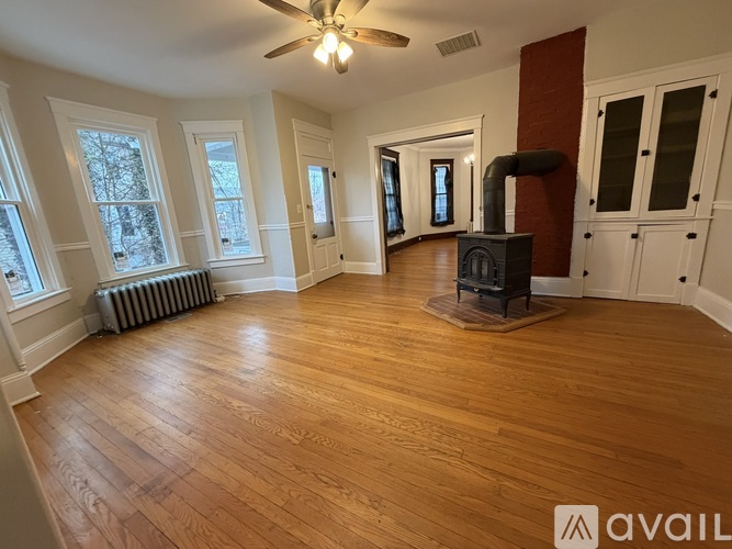 A living room with wood floors and a fireplace.
