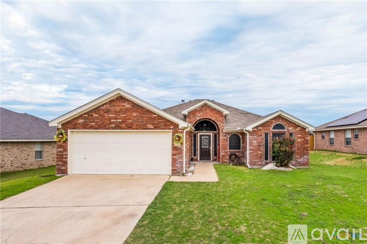 A brick house with a garage door and a driveway in front.
