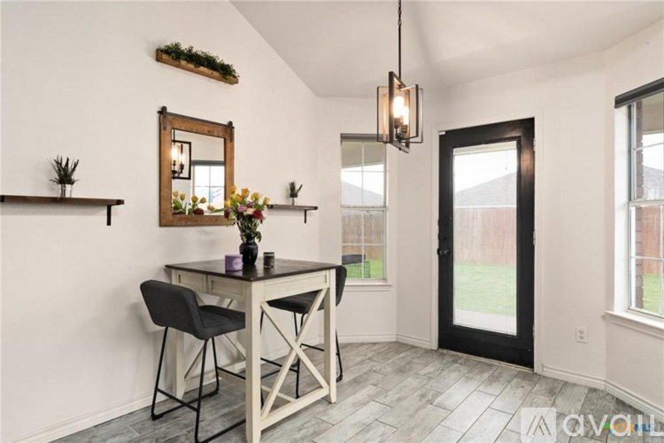 A dining room with a table and chairs.
