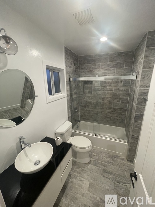 A bathroom with a sink, toilet, and shower.