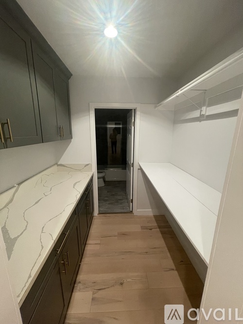 A kitchen with a marble countertop and wooden flooring.