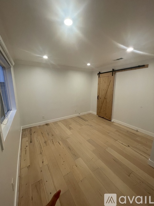 A room with wooden flooring and a sliding door.