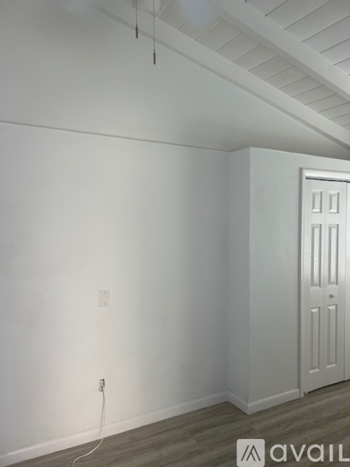A room with a white door and a light switch on the wall.