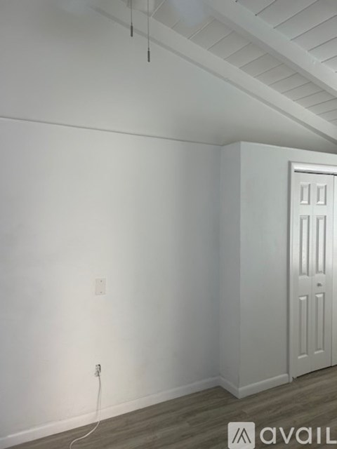 A room with a white door and a light switch on the wall.