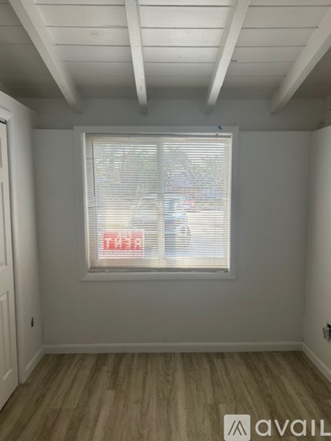 A room with a window covered in blinds.