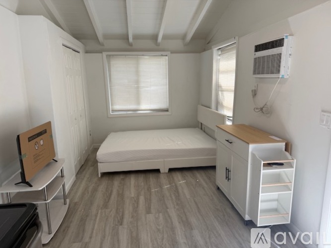 A small bedroom with a bed, dresser, and window.