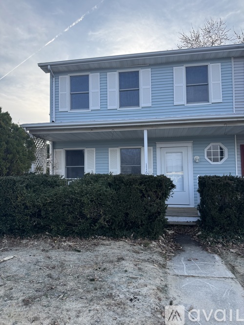 A blue house with a white door and windows.