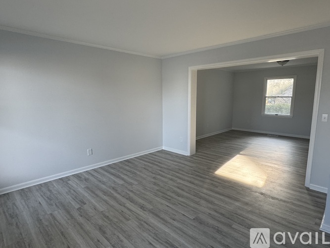 A room with wooden flooring and white walls is available for rent.