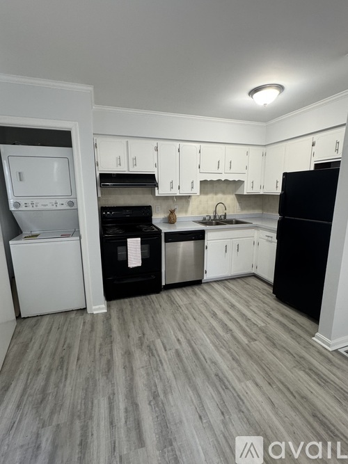 A kitchen with black appliances and white cabinets.