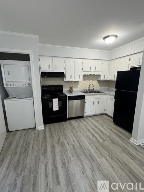 A kitchen with black appliances and white cabinets.