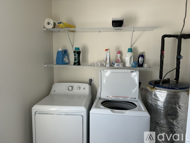 A white washing machine and dryer are in a small laundry room.