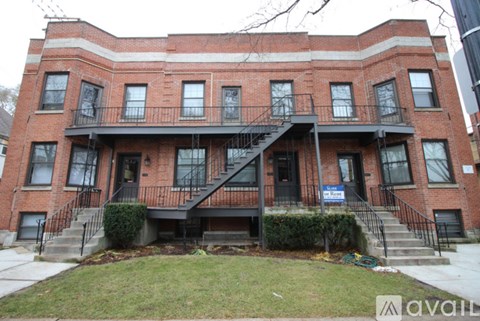 A red brick building with a black staircase in front.