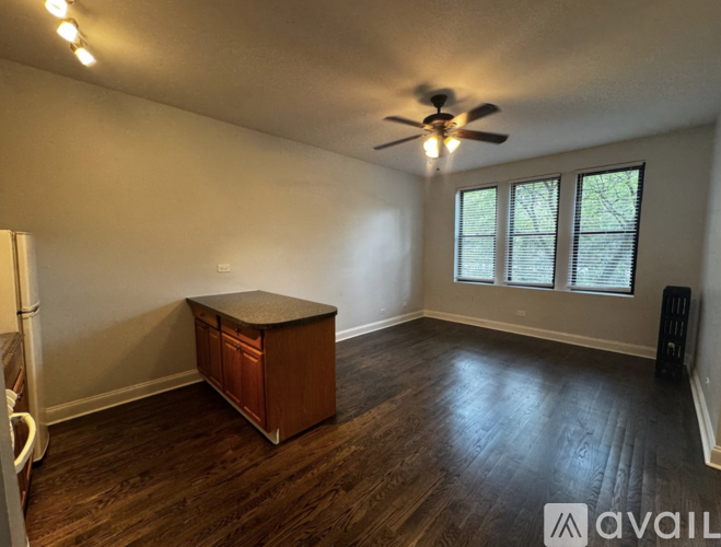 A room with a ceiling fan and a wooden cabinet.