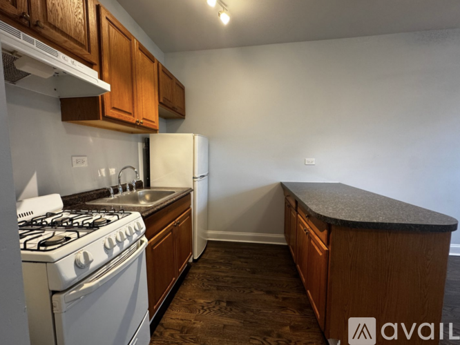 A kitchen with a white gas stove and wooden cabinets.