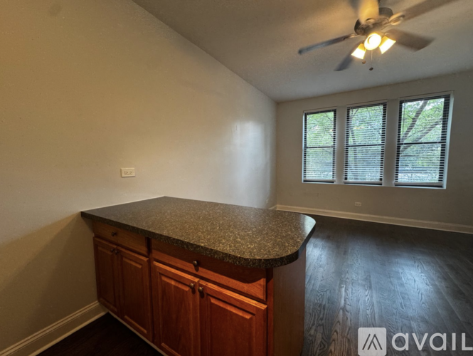 A kitchen with a granite countertop and wooden cabinets.