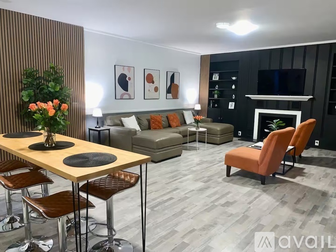 A modern living room with a wooden table and orange chairs.