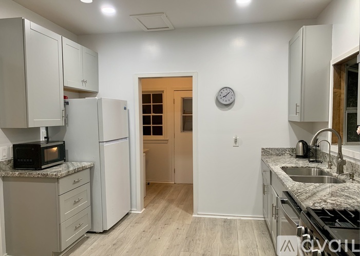 A kitchen with white cabinets and a granite countertop.