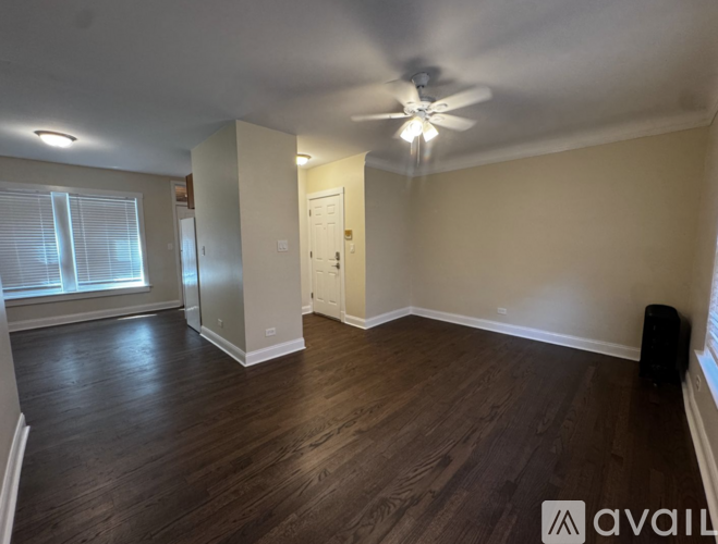A room with wooden floors and a ceiling fan.