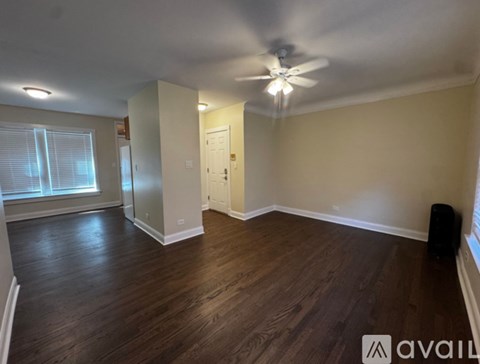A room with wooden floors and a ceiling fan.