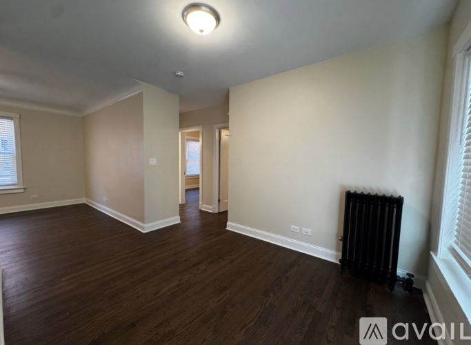 A room with wooden floors and a black radiator.