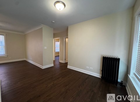 A room with wooden floors and a black radiator.