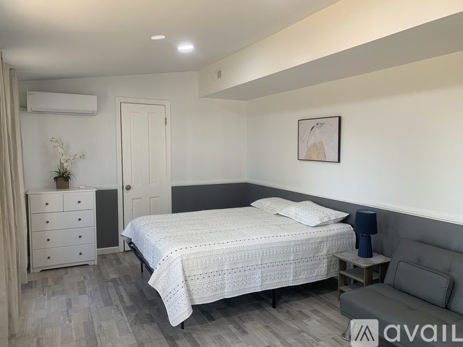 A bedroom with a bed, dresser, and chair.