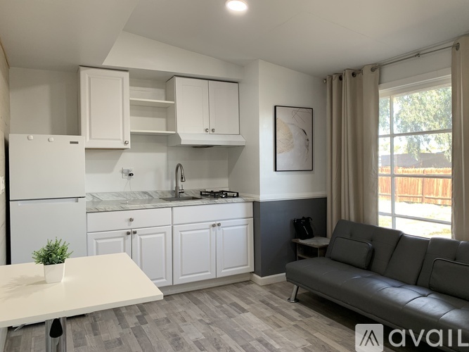 A modern kitchen with white cabinets and a marble countertop.