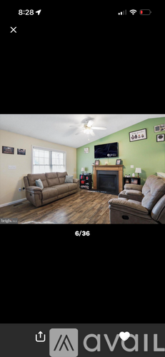 A living room with a fireplace and a television mounted on the wall.