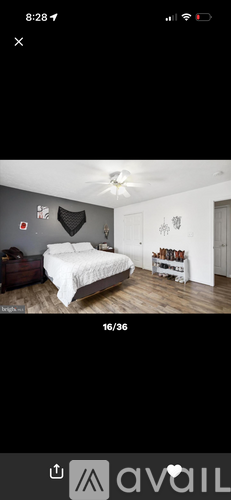 A bedroom with a white bed and a grey wall.