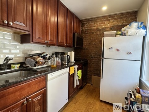 A kitchen with a white fridge and wooden cabinets.