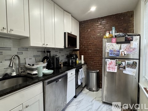 A kitchen with a refrigerator covered in papers and magnets.