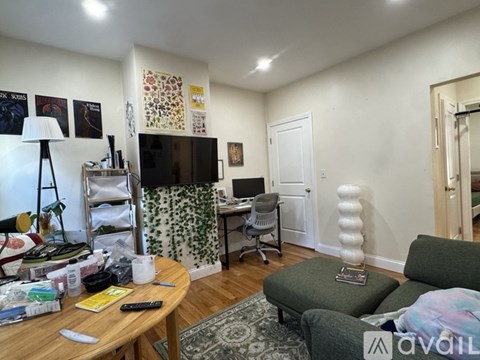 A living room with a green couch, a wooden coffee table, and a white lamp.