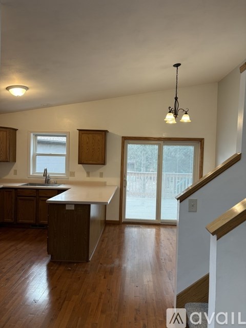 A kitchen with wooden floors and a white counter top.