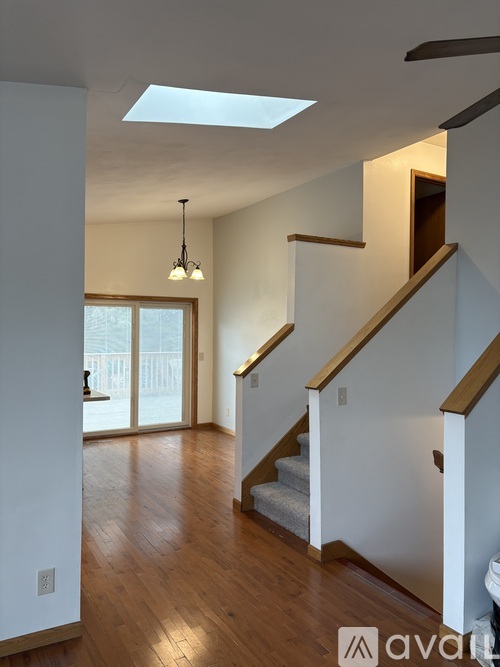 A wooden staircase with a skylight above it.
