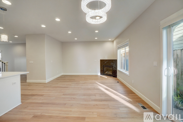 A spacious living room with a fireplace and hardwood floors.
